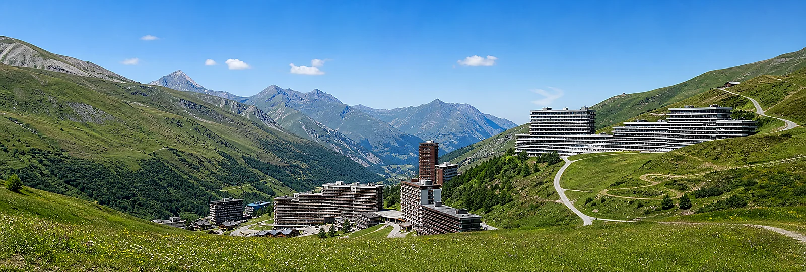 Les Menuires summer resort and green mountain slopes